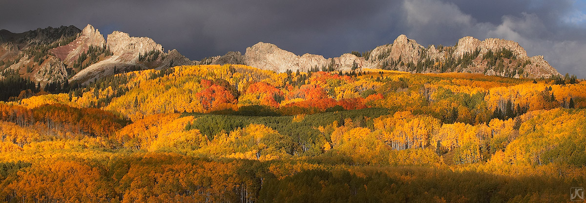 Near Kebler Pass, sunset light hits the Ruby Range, the Dyke and the autumn aspen forest below.