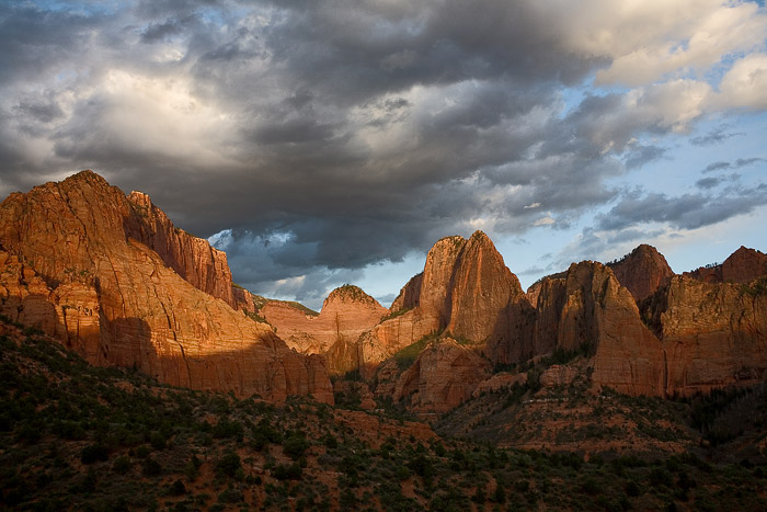 The soft light of the late afternoon sun hits the upper half of the great rock features that dominate Kolob Canyon in Zion National...