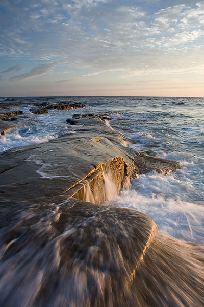 Incoming water forces its way up and onto a coastal shelf near La Jolla, California.