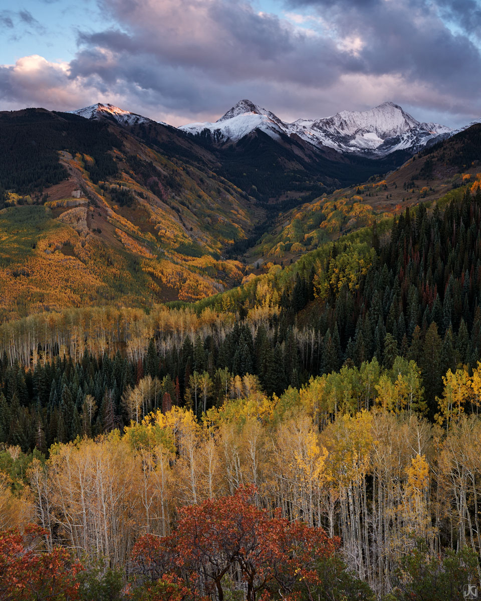 Autumn colors are showcased here in this valley filled with aspen and scrub oak, as the evening light hits the peaks and clouds...