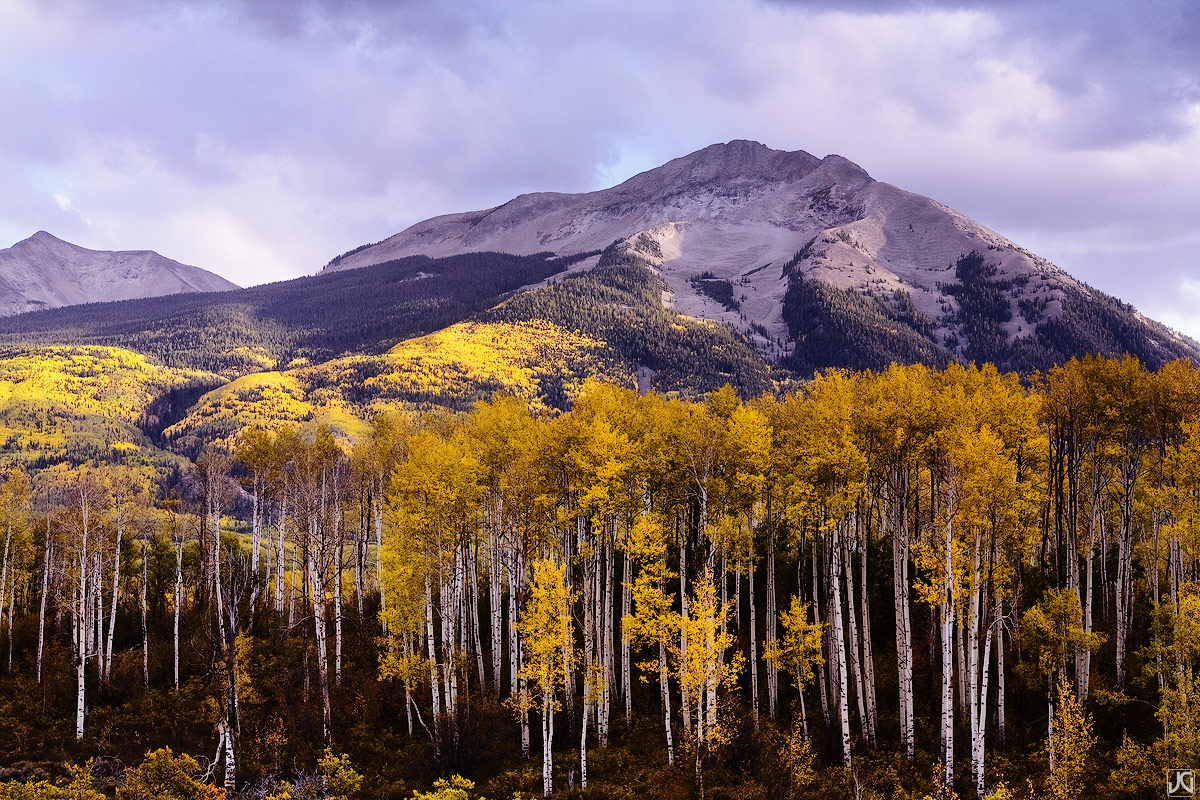 Clouds, sun and the autumn aspen colors mix under West Beckwith Mountain in the West Elk Mountain Range of Colorado.