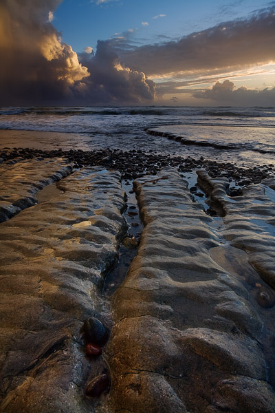 The last light of the day brings a gold tone to the rocks and approaching storm.