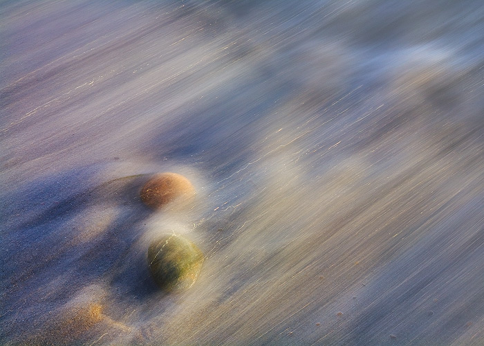 These stones appear to be in motion, as the tide moves in during sunset along the coast.&nbsp;