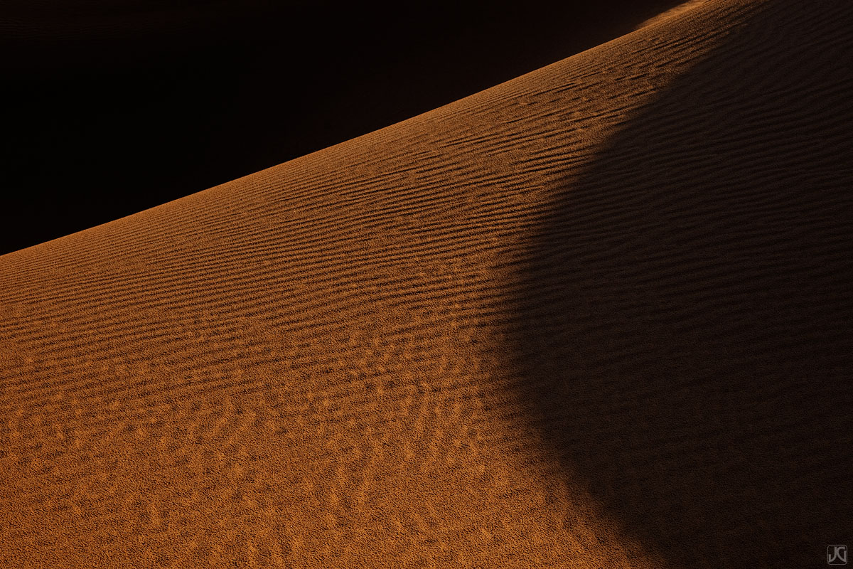 The low light at sunset creates long and interesting shadows across these sand dunes near Glamis, California.