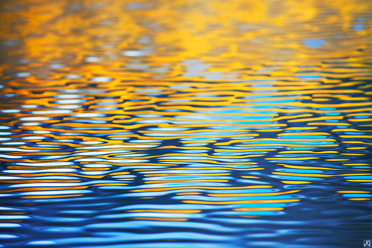 Aspen trees across the lake create colorful reflections during autumn in Colorado.&nbsp;