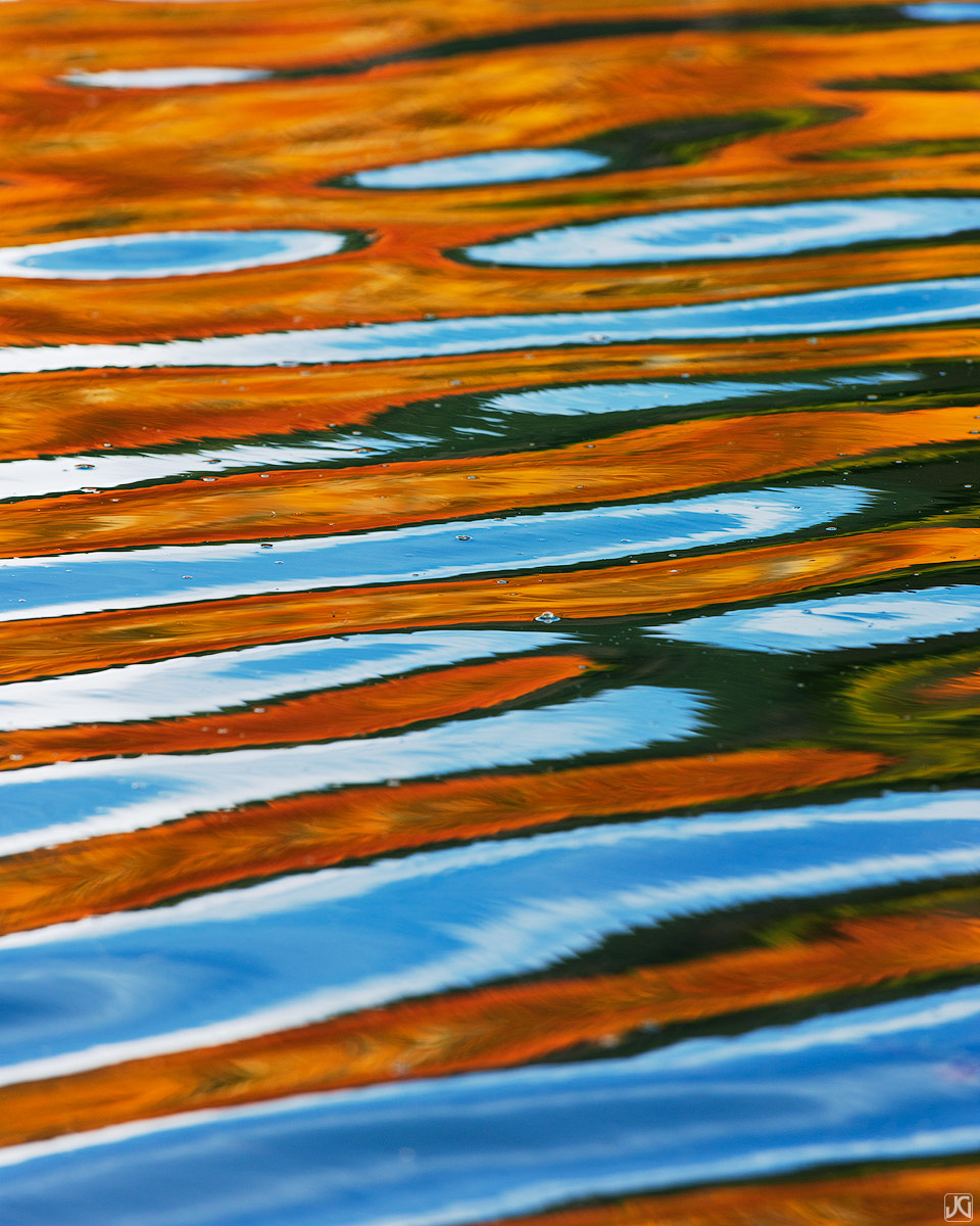 Aspen trees across the lake and the blue sky above create colorful reflections during autumn in Colorado.&nbsp;