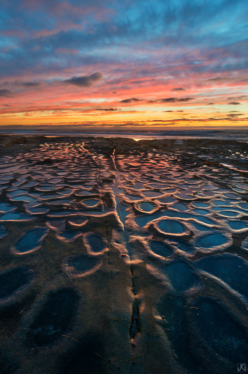 This large colony of potholes is often filled with water and holds the color reflected off the clouds and sunset.