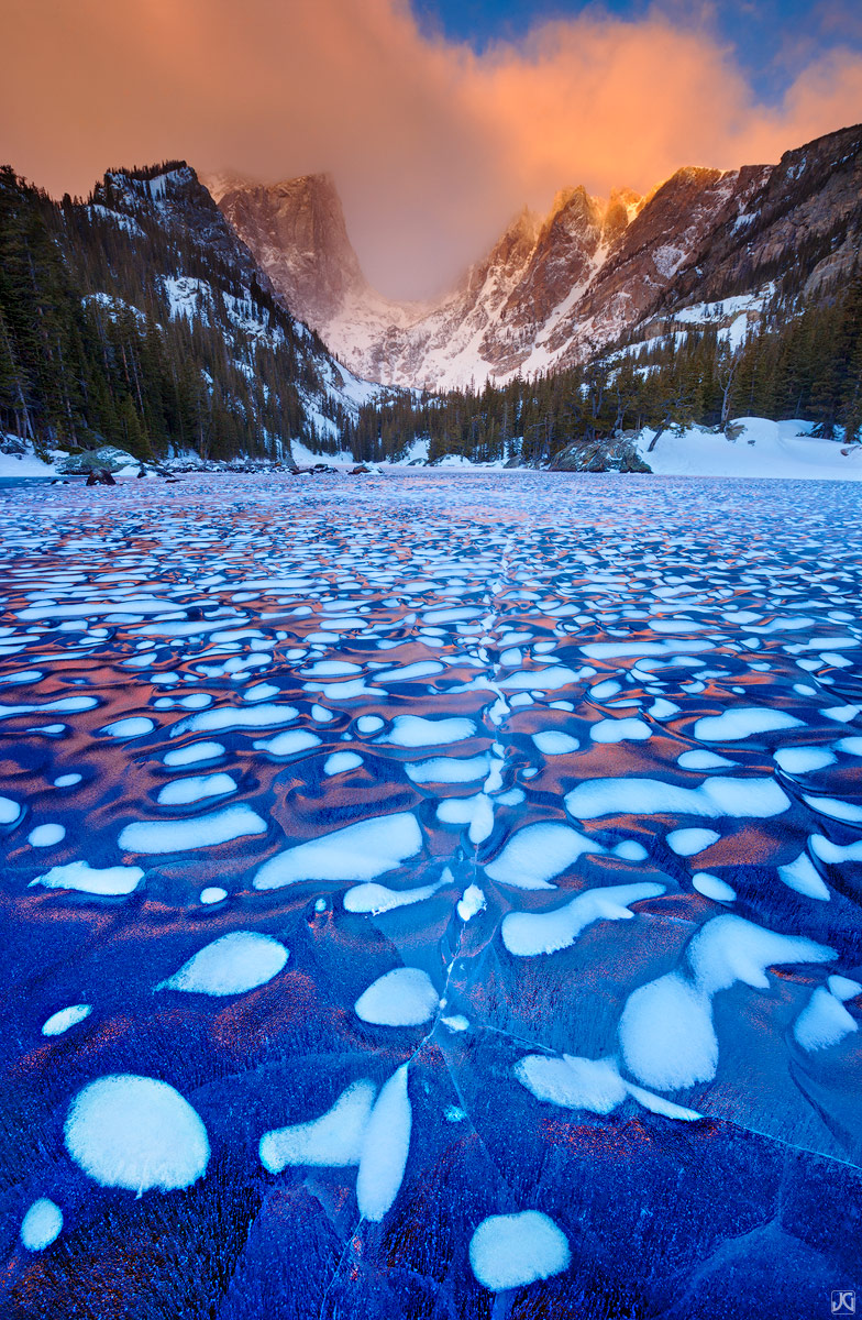 A winter sunrise illuminates the mountains above the wonderful ice patterns of Dream Lake.