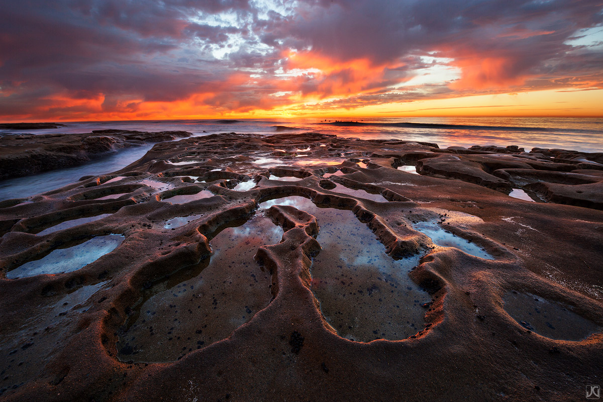 A dramatic sunset along the coast of La Jolla brings amazing colors to the sky and reflections in the pools.