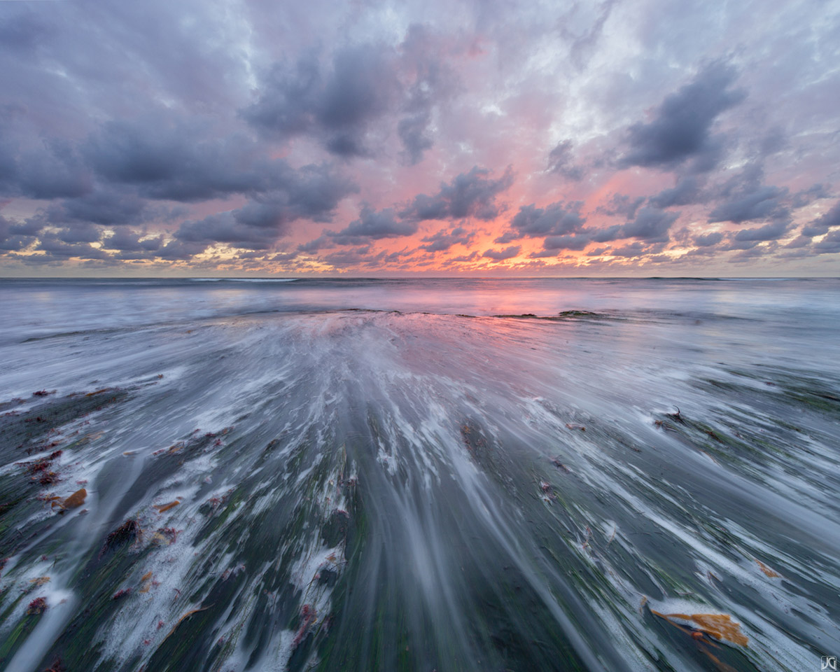 Low tide showcases the sea grass during a colorful sunset along Swami's Beach near San Diego.
