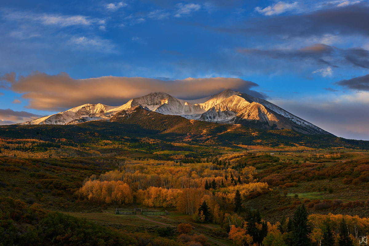 Sunrise lights up the clouds around Mount Sopris, while the soft light of the morning creates a glow around the autumn aspen...