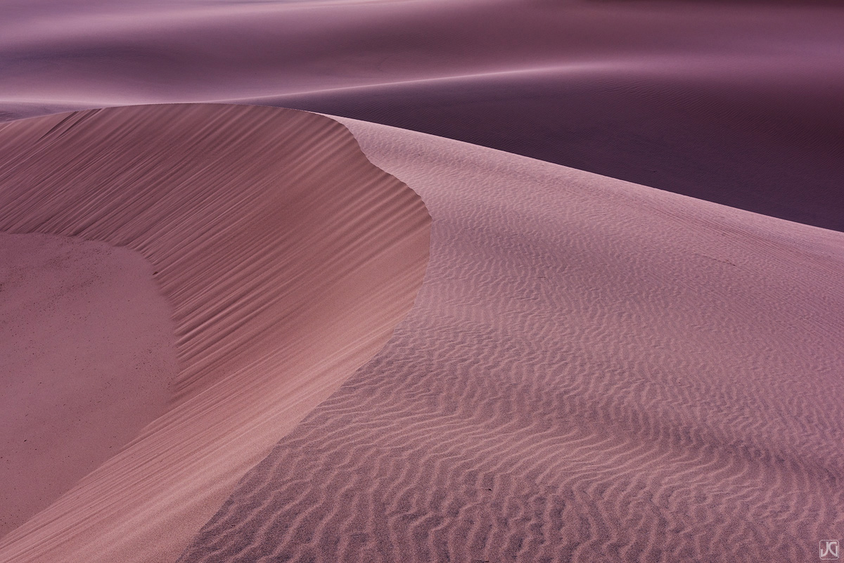 Early evening light falls on the dunes, transforming the sand and shadows.