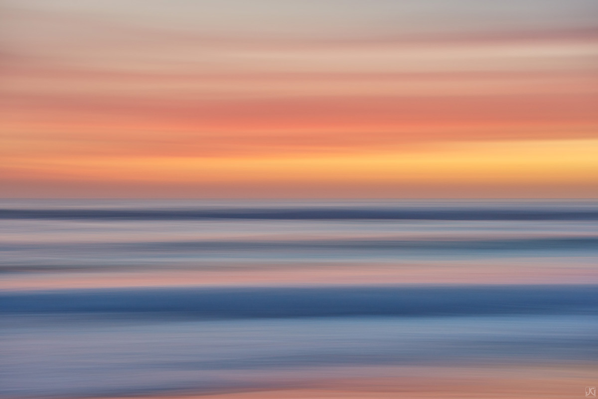 Color strands of clouds above the ocean at sunset along the coast of California.