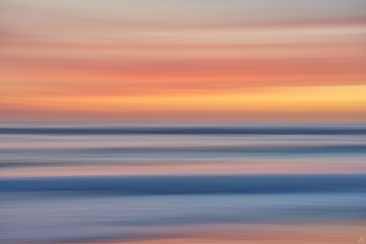 Color strands of clouds above the ocean at sunset along the coast of California.