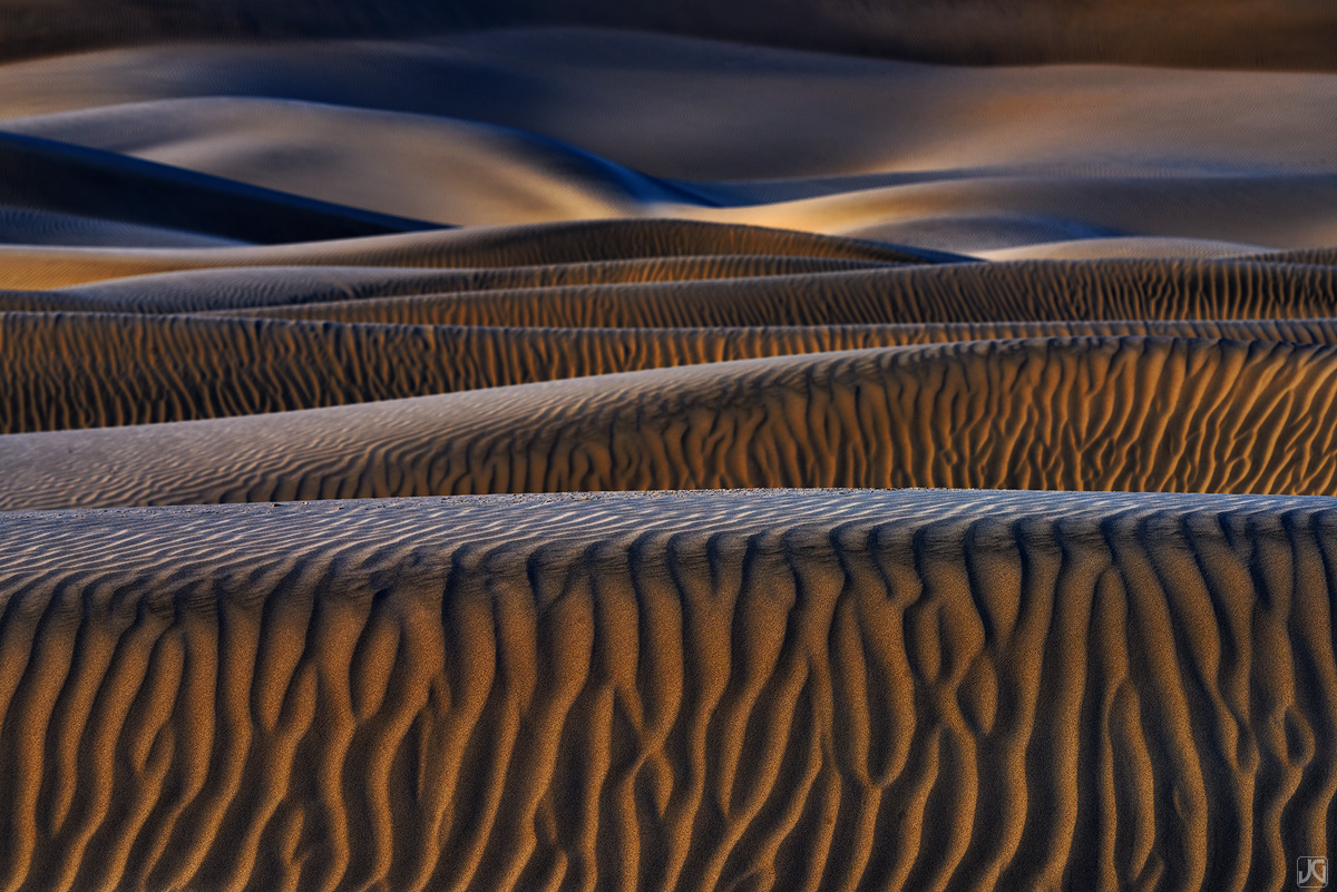 Soft, diffused light over the dunes brings out the shadow hues and textures in the sand.