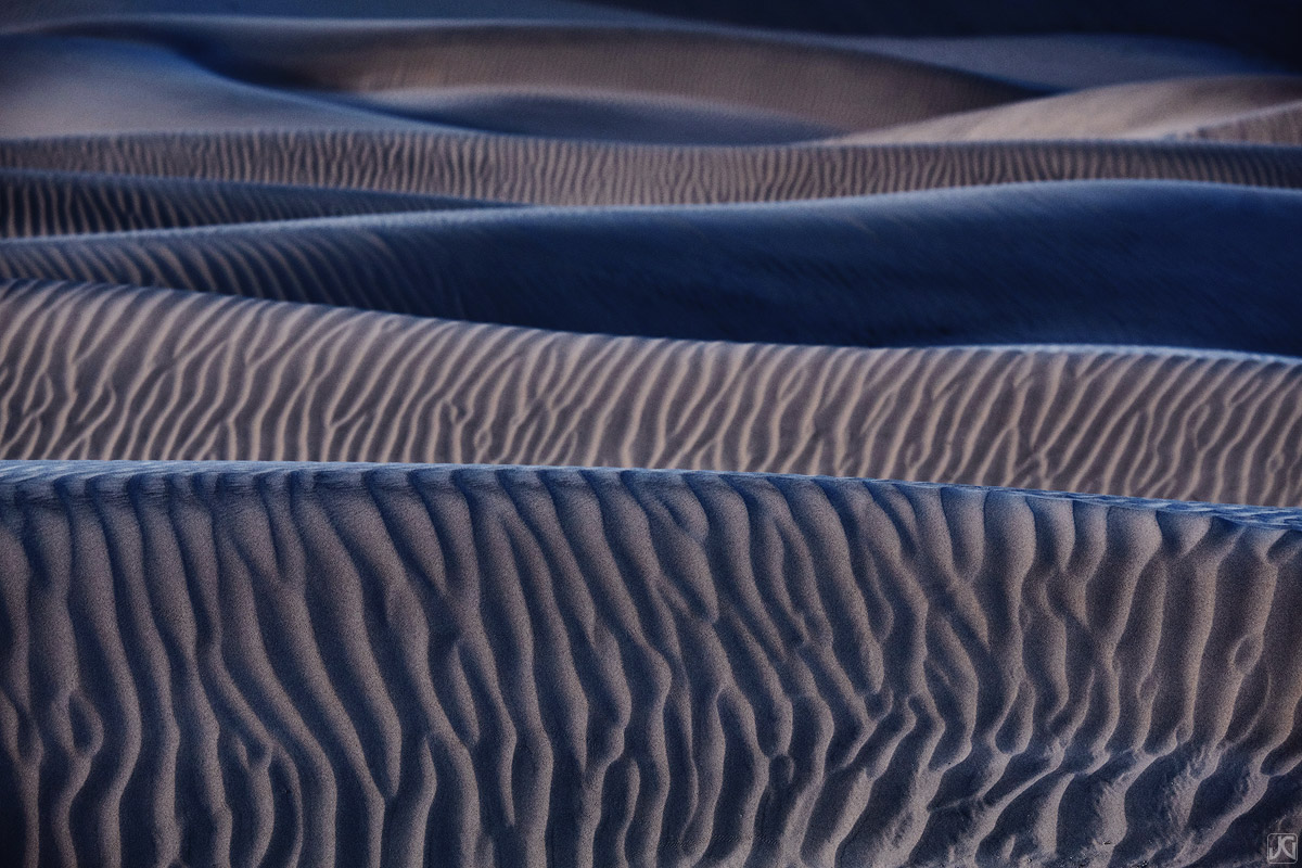 Twilight colors enhance the shapes and patterns on these sand dunes in the desert of California.