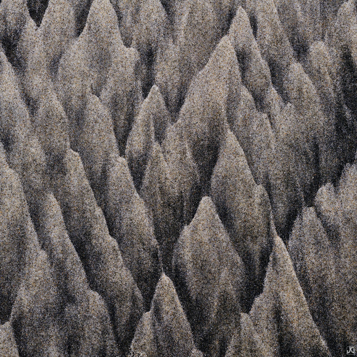 Sand patterns form what appears to be a dense mountain range.