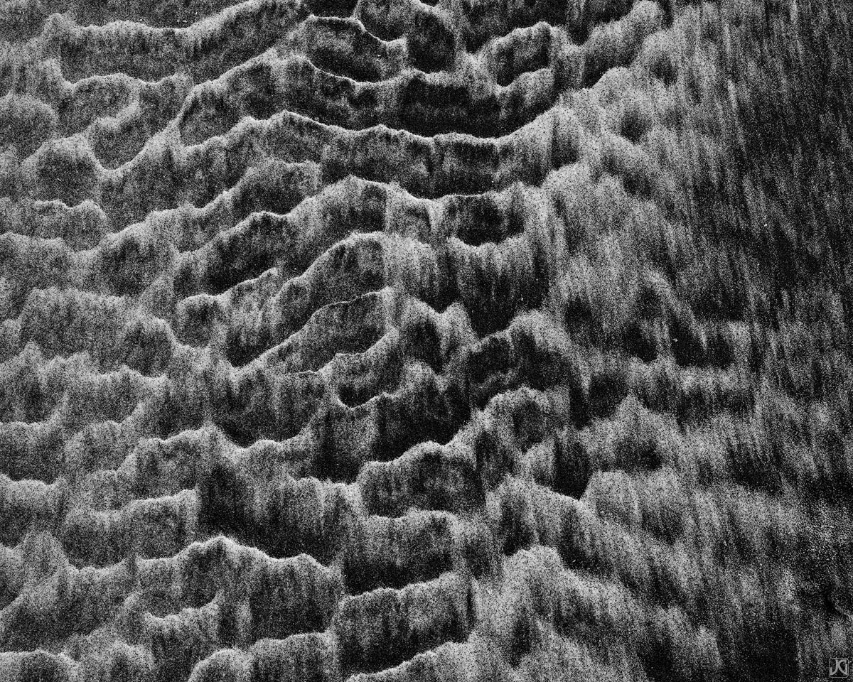 On the edge of a rainwater runoff zone, these sand patterns form ridges that will soon be washed away.