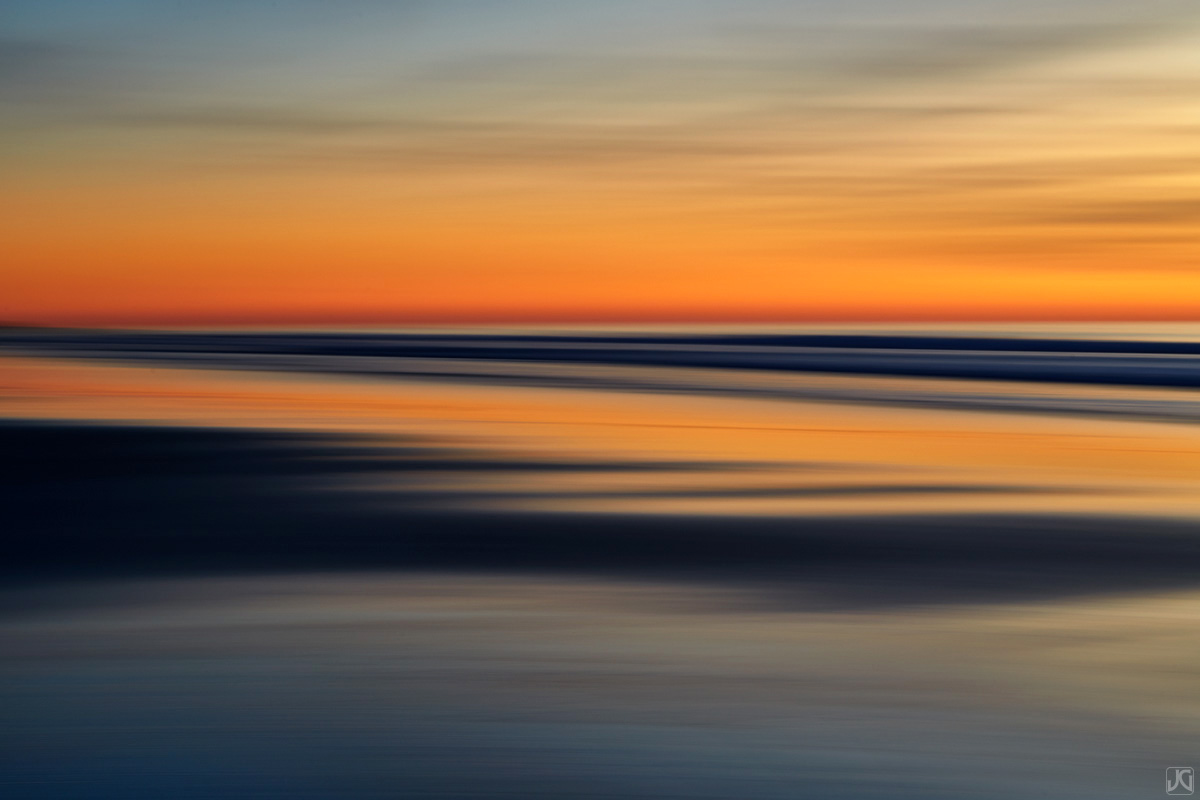 A soft hue after sunset is cast across the sand and sky.