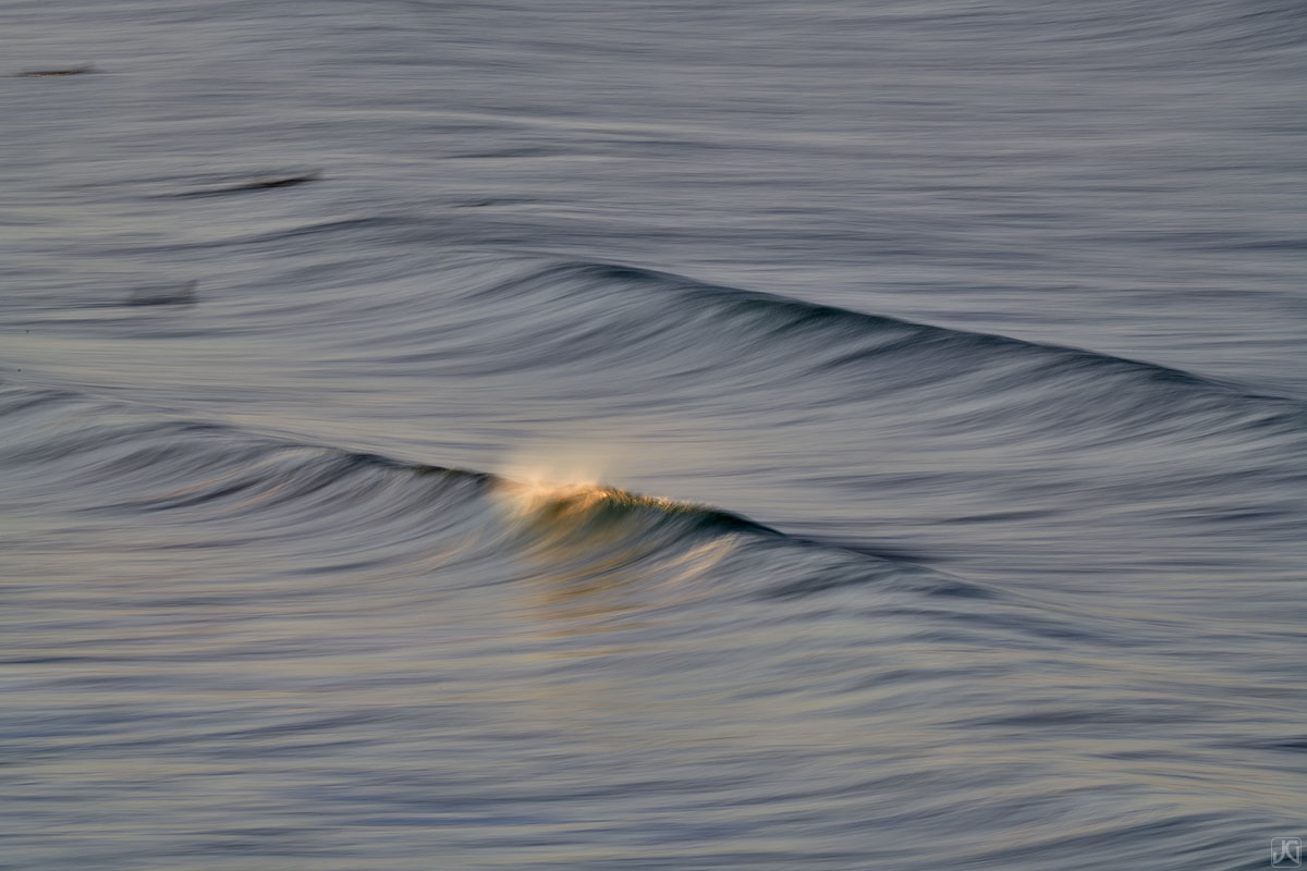 Offshore winds and sunrise light flow across the waves.