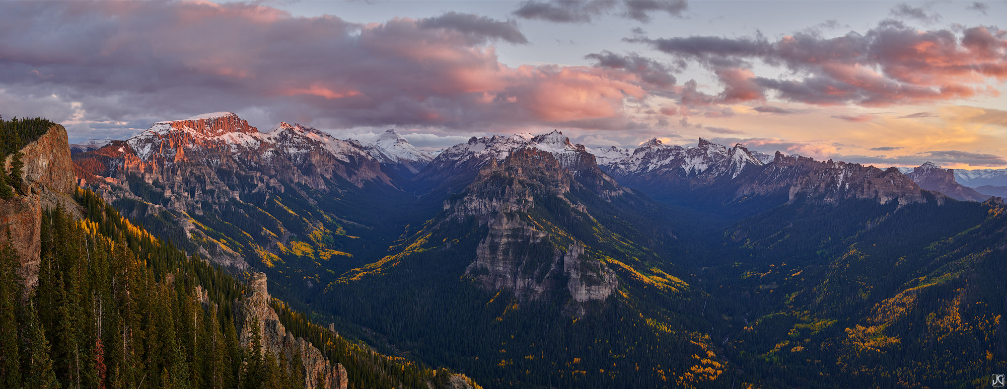 The last rays of sunset light hit the clouds and ridges of the Cimarron Mountains on a cold, autumn evening.